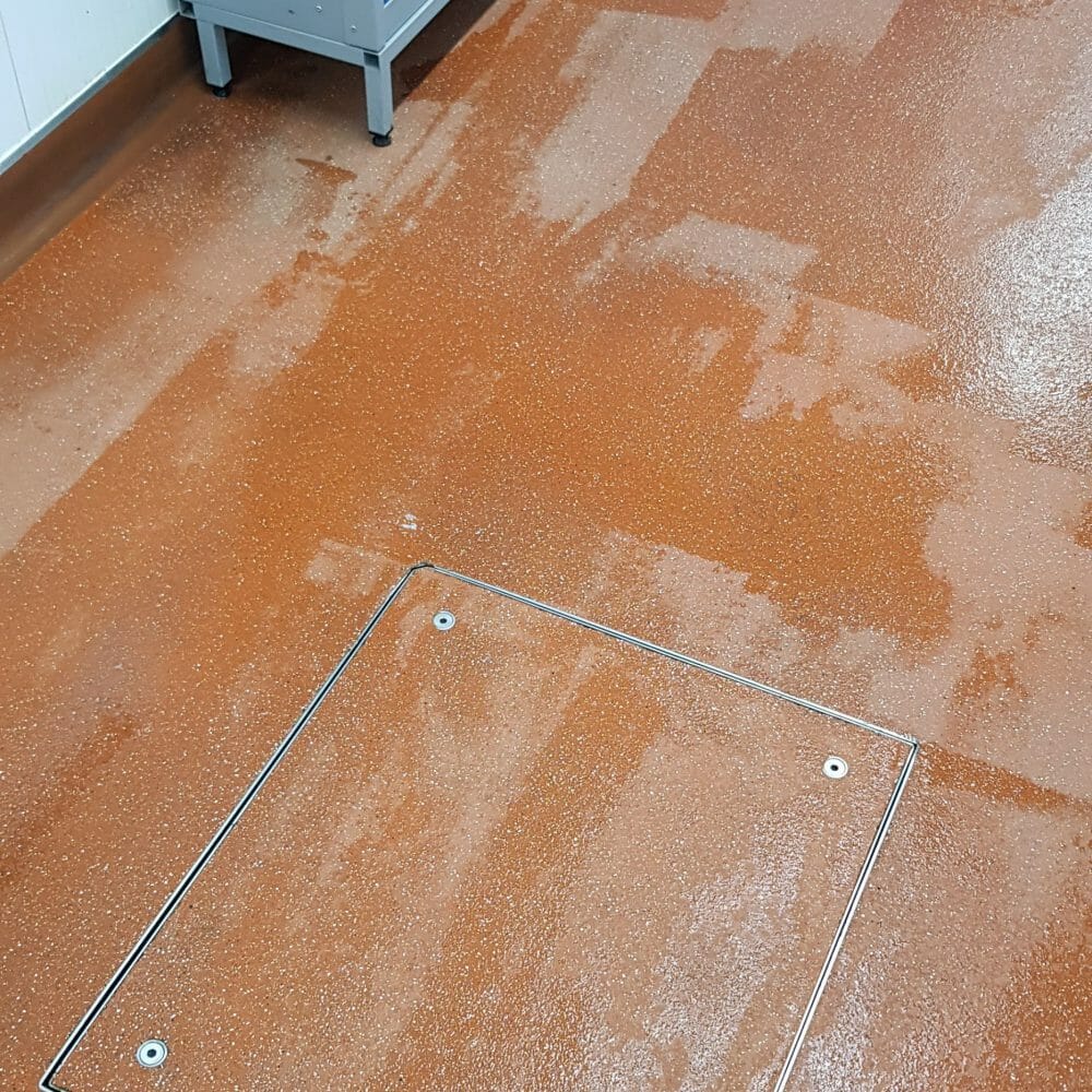 The final result of an industrial floor restoration at CP Foods, showing a clean, hygienic, and slip-safe staff walkway.