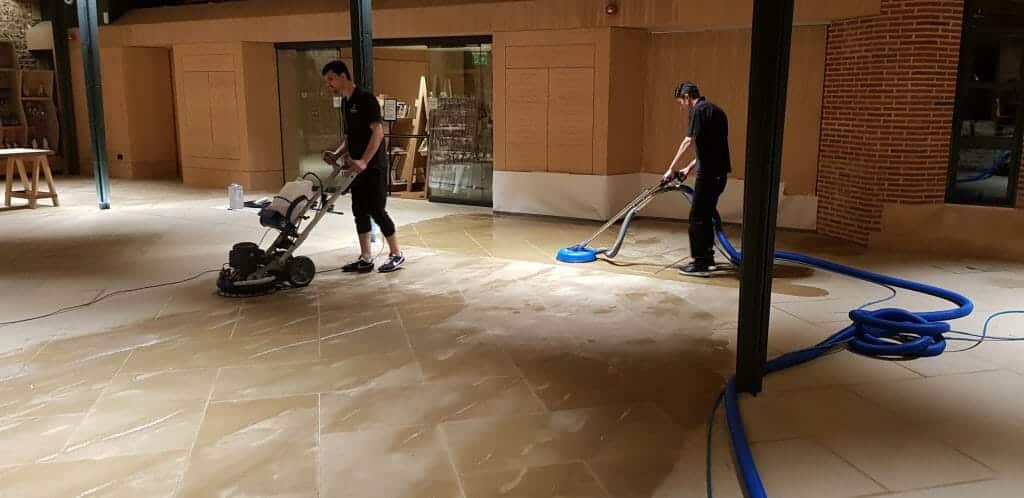 Prestige stone technician using a mechanical orbital cleaner on Yorkstone at St Albans Abbey.