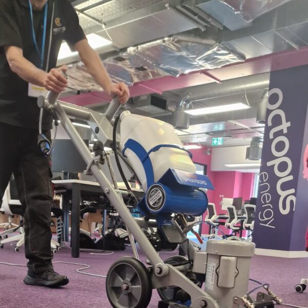 Prestige technician cleaning commercial carpet tiles at Octopus Energy office, Oxford Street, using the HOS Orbot Low Moisture Carpet Cleaning System.
