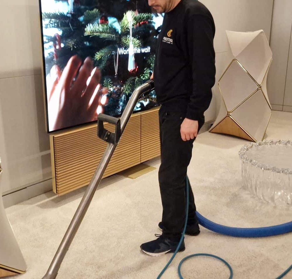 Specialist commercial carpet cleaning in a luxury retail environment around sensitive electronics and displays.