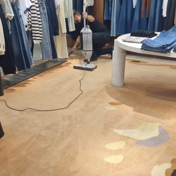 detail-rug-cleaning-harrods-knightsbridge-sebo-dart.jpg Detailed view of a Prestige technician performing precision vacuuming around fixed display stands at Harrods, Knightsbridge, using a specialised Sebo Dart crevice tool.