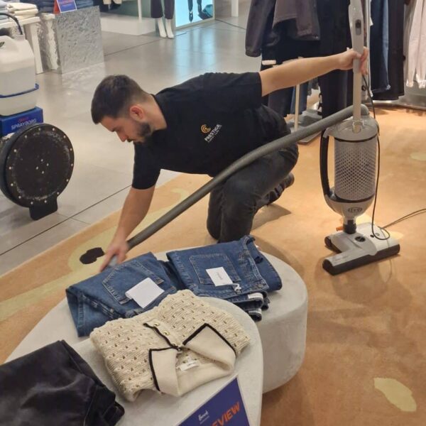 precision-vacuuming-harrods-knightsbridge-display-stands.jpg Prestige technician using a Sebo Dart vacuum with a crevice tool for precision edge cleaning around a display stand at Harrods, Knightsbridge.
