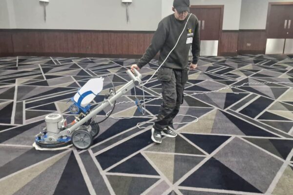 Prestige technician cleaning large function room carpets in the Galleon Suite at the Royal National Hotel, Bedford Way, London WC1.