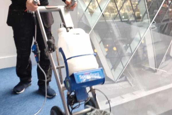 Prestige Commercial Carpet Cleaning technician using an Orbot machine for office carpet tile cleaning in the City of London with The Gherkin in the background.
