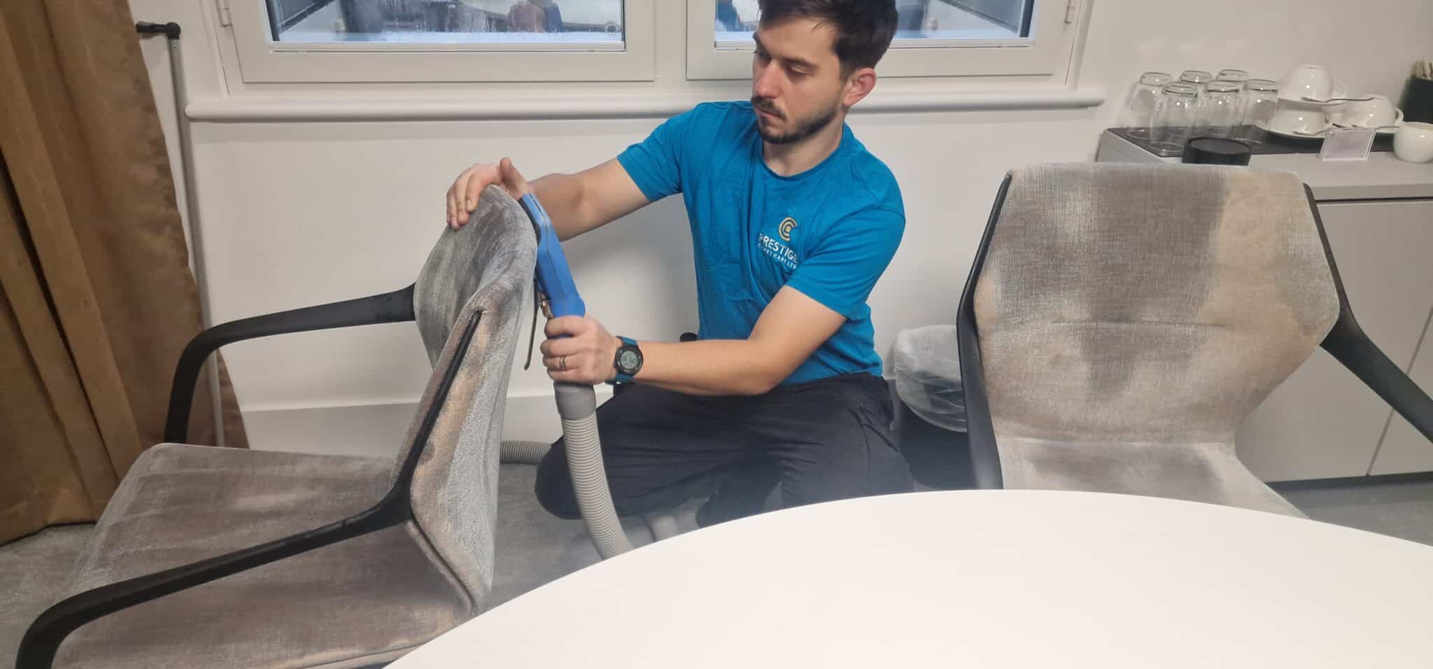 Prestige Commercial staff using specialised hot water extraction equipment to deep clean a fabric office chair for James Hambro & Partners at 45 Pall Mall, London.